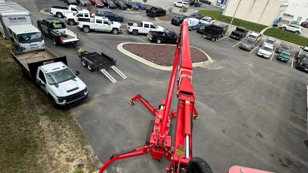 Kenny's Tree Removal removing tree with spider lift for John Heister Chevrolet in Fuquay Varina NC.